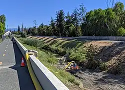 In July, 2019, the entire flow of the creek is diverted through a hose for creekbed weed cleanout by the Google campus.