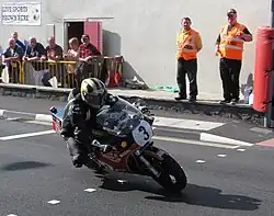 Michael Dunlop (3) Suzuki — Formula 1 Classic TT 2013 - Lap 3 Parliament Square, Ramsey 26 August 2013