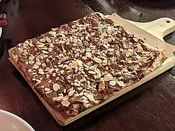 Nutella sprinkled with sliced and toasted almonds on a square pizza in São Paulo