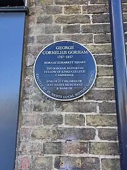 Plaque which reads 'George Cornelius Gorham 1787-1857 Born at 22 Market Square Theologian, historian, fellow of Kings Colledge Cambridge One of 12 children of a St Neots merchant & banker'