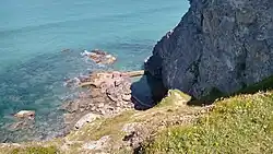 Photo showing a view down Eastcliff down towards the sea and the tidal pool in the rocks.