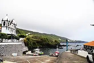 The fishing port and coastal perspective of Calheta de Nesquim, with the parish church dedicated to São Sebastião
