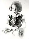 First commissioned portrait of a very young girl looking deep in thought with soft highlights, fitted dress with brass buttons, white lace collar