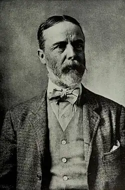 Black and white portrait of a man with full beard, about 56, dressed in a three-piece suit with a bowtie.