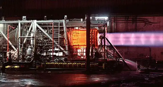 This picture of an uninstalled engine being tested illustrates the need for cooling air around the exhaust duct. The engine, when installed as part of the powerplant, has secondary cooling air at 1,200 °F (650 °C) passing over the afterburner duct which is heated internally by combustion up to 3,200 °F (1,750 °C). The heating, followed by the primary nozzle restriction, accelerates the exhaust to sonic speed as it leaves the primary nozzle (shown). The ejector nozzle (not shown) surrounds the primary exhaust with secondary and tertiary air to cushion its expansion in the ejector nozzle.