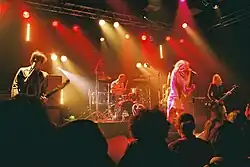 A four-piece band performing live on a stage