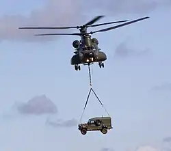 A Royal Air Force Chinook carrying a British Army Land Rover as an under slung load.