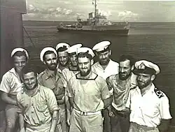 Image 57Australian sailors with a Bathurst-class corvette in the background. The RAN commissioned 56 of this class of corvettes during World War II. (from History of the Royal Australian Navy)