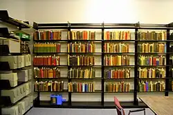 Several wall-mounted bookshelves contain books of various colors