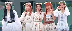 An image of Joy, Yeri, Irene, Seulgi and Wendy, with flowers on their hair. Excluding Joy, the four women are seen doing hand signs.