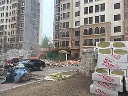Taitou apartment exterior walls with cladding being removed by workers on cranes