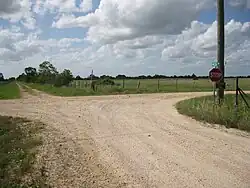 View is northwest at junction of Mieth and Rexville Rds. The railroad once followed the line of trees on the horizon.