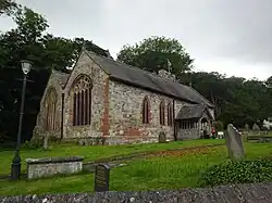 Side view of the church showing the double nave, the south porch and the offset western tower