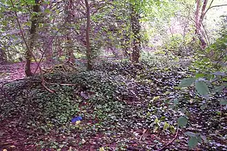 Apparent ruined walls in bricks covered by earth
