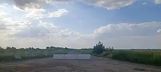 Russian anti-tank defense line in Zaporizhzhia Oblast with chained together dragon teeth and a concrete road block
