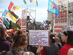 The sign of an anti-government protester: "To the commander and personnel of the Mariupol military unit 3057, those who shot unarmed people are an indelible sin! Eternal damnation!"