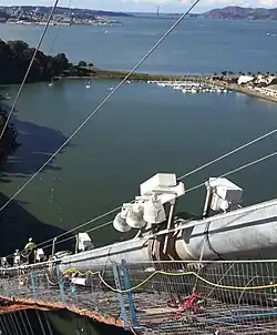 Following saddle placement, the final S-wire wrap has been applied and main span lighting fixtures mounted.