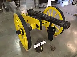 Photo shows a cannon with its carriage painted yellow.