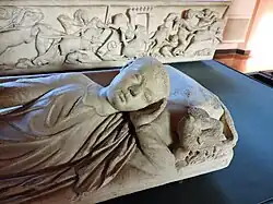 Sarcophagus cover with deceased youth supine and resting his head on two cushions, 3rd century AD. On display at Museum-Lapidarium of Maffei.