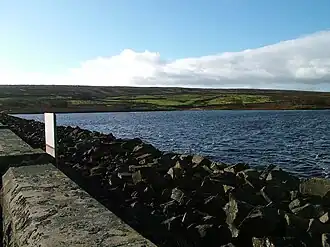 A dam head, with upland beyond the water