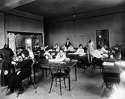 Young women at sewing machines and tables