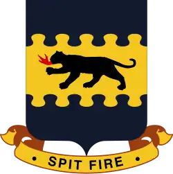 An insignia with a dark four-legged feline breathing fire on a yellow background. There is a blue artistic border at the top and bottom. Below a banner reads "Spit fire".