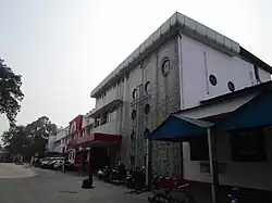 Front of a station, with parked cars and motorcycles