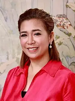 Aragones wearing a red satin blouse