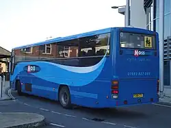 Rear of blue 'Moss'-branded Premiere coach with vertical taillights and a flat rear window