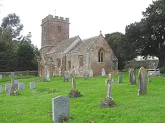 Beyond the pair of red stone semis is the village hall.