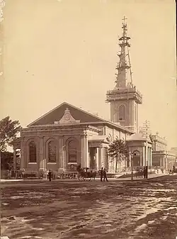 An old photo showing the church with a muddy road in the foreground and scaffolding around the spire.
