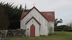 An old wooden church in a grassy area