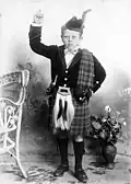 Boy wearing open necked velvet doublet, kilt and plaid (1898)