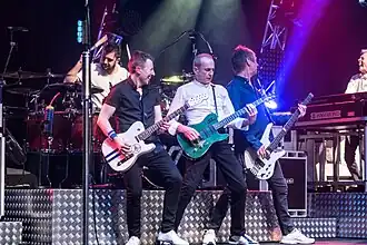 Status Quo performing in 2017 From left: Leon Cave (on drums), Richie Malone, Francis Rossi, John "Rhino" Edwards, Andy Bown