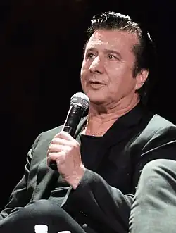 The singer Steve Perry speaking into a microphone