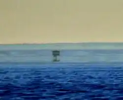 In this mirage, at least three separate images of a boat are visible. The real one at the bottom and the uppermost one are in the upright position, whereas the one in the middle is inverted.