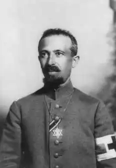 Military Field Rabbi Dr. Aaron Tänzer during World War I, with the ribbon of the Iron Cross.[84] The brassard of the red cross shows him as noncombatant. He wears the Star of David as insignium