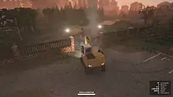 A screenshot showing a third-person perspective of the player in an excavator, breaking open a locked metal gate using the excavator's shovel. The background beyond the gate features a van, utility poles, and trees.