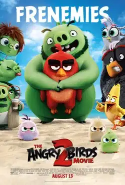 Film poster showing Leonard (a bearded green pig) hugging Red (a red bird) at the beach. On the left are three green pigs, on the right are three birds. Beneath are three angry hatchlings. Beneath the characters is the title of the movie. Above the poster is the text "FRENEMIES". The credits and production details are beneath the poster.