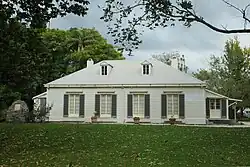 A large white building in a grassy environment