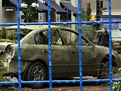 Film set of an actor walking among broken cars
