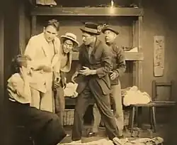 Black and white film still showing a woman in distress