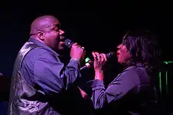 Both members of The War and Treaty singing into microphones