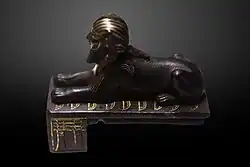 The Bronze Sphinx of Thutmose III reclining over the Nine Bows; the Djed pillars of Dominion are featured on the side of the socle