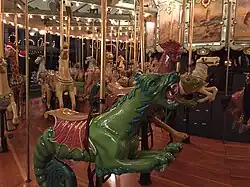 A green sea monster ride figure on a historic carousel