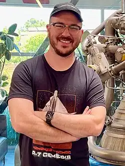 head and shoulder shot of Dodd crossing his arms and smiling