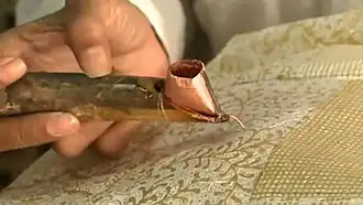 A canting in use to draw a resist pattern in molten wax