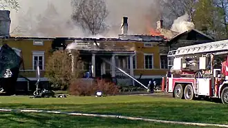 Tjusterby Manor burns in Siuntio with firetrucks present trying to stop the fire.