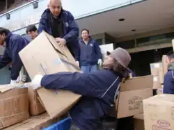 Sathya Sai Youth carrying the relief item boxes to be loaded onto the coast guard patrol boats.