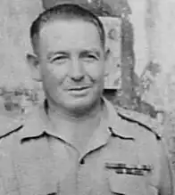A black and white head and shoulders photograph of a middle-aged man in uniform